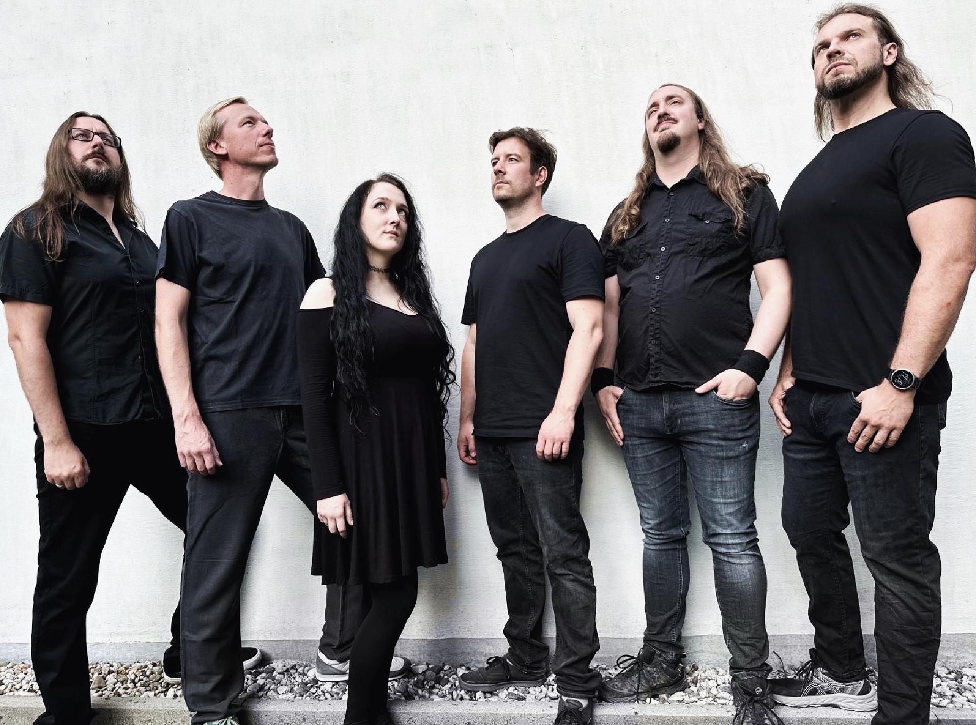 Bandfoto von Metascope, einer symphonischen Prog-Metalband mit sechs Mitgliedern in schwarzer Kleidung.